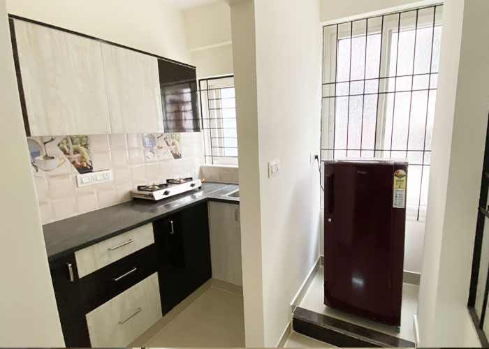 Kitchen and refrigerator at S V Moon Homes in Munnekollal