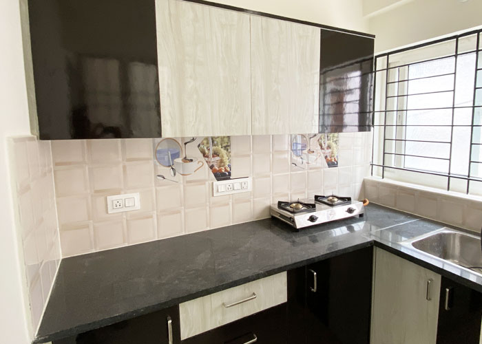 Kitchen with cabinets, hob and sink at S V Moon Homes in Munnekollal